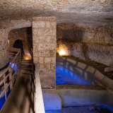 Le vasche scavate ai nostri piedi, oggi vuote e illuminate da una forte luce blu, un tempo erano probabilmente gli spazi in cui si raccoglievano le riserve di acqua
